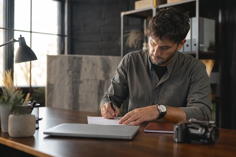 Producer desk with a signed release form, pen, a closed ID booklet and a camera before a booking
